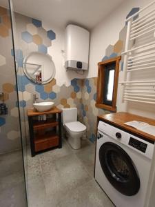 a bathroom with a toilet and a washing machine at Miejsce dla chcących odpocząć in Prabuty
