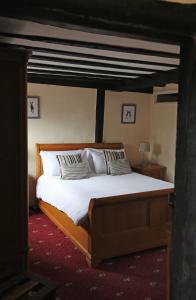 a bedroom with a bed with white sheets and pillows at The Brickwall Hotel in Sedlescombe