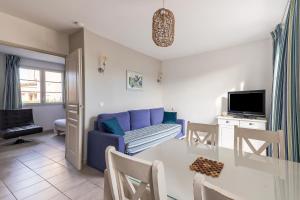 een woonkamer met een blauwe bank en een tafel bij L'Arbois - T2 avec piscine entre Aix et Marseille in Cabriès