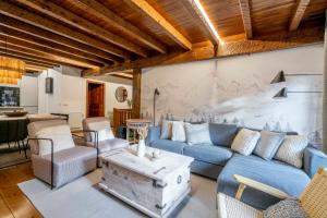 a living room with blue couches and a table at Casa Baciver by FeelFree Rentals in Garós