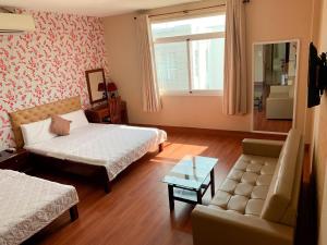 ein Wohnzimmer mit 2 Betten und einem Sofa in der Unterkunft NGỌC MẤY - ĐẠI LỢI HOTEL in Chau Doc