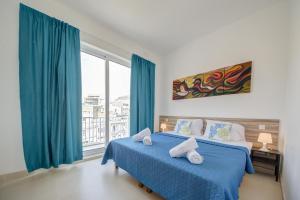 Un dormitorio con dos camas y una gran ventana. en Tranquil Msida Creek 1-Bedroom Apartments & Penthouse, en Msida