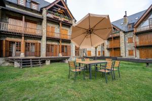 a table and chairs with an umbrella in front of a building at Casa Baciver by FeelFree Rentals in Garós