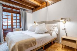 a bedroom with a large bed with white sheets at Casa Baciver by FeelFree Rentals in Garós