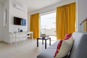 una sala de estar con un sofá y una mesa en Tranquil Msida Creek 1-Bedroom Apartments & Penthouse, en Msida