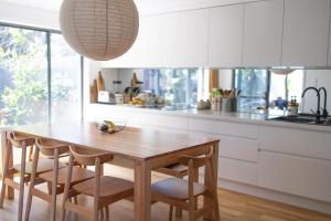 a kitchen with a wooden table and chairs at Sea Notes Yamba in Yamba