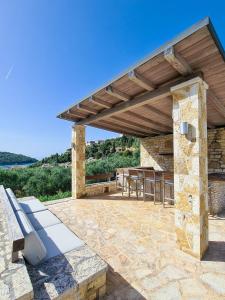 a stone patio with a wooden pergola at SAZ VILLAS in Syvota