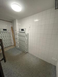 an empty bathroom with white tiles on the wall at Penzion Erika in Boží Dar