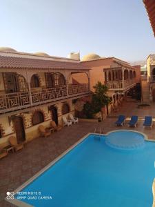 um hotel com piscina em frente a um edifício em Jimmy Hotel em Dahab