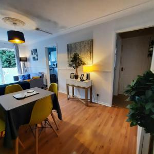 a living room with a table and yellow chairs at Blenheim Way is a beautiful apartment in a quiet location yet minutes from major attractions and City centre Great for families Sleeps 6 in Birmingham