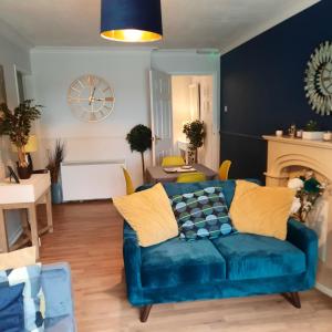 a living room with a blue couch and a table at Blenheim Way is a beautiful apartment in a quiet location yet minutes from major attractions and City centre Great for families Sleeps 6 in Birmingham
