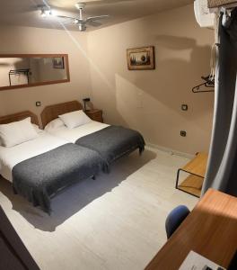 een slaapkamer met een bed in een kamer met een tafel bij Hostal Arenal in Zaragoza