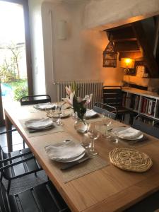 - une table en bois avec des assiettes et des verres à vin dans l'établissement Maison de famille du 17ème siècle, 