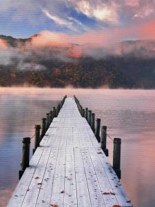 a pier stretches out into the water on a lake at Superbe appartement terrasse wifi in Paroy-sur-Tholon