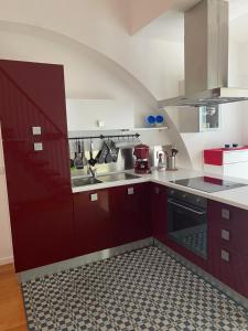 uma cozinha com armários vermelhos e um piso preto e branco em RESIDENCE DUINO MARE em Duino