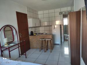 uma cozinha com um lavatório e um balcão com bancos em Kitnet da Fô em Pelotas