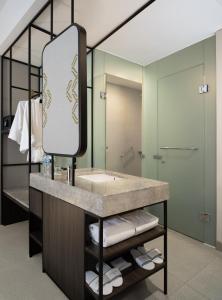 een badkamer met een wastafel en een spiegel bij Hotel Santika Premiere Padang in Padang