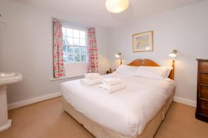 a bedroom with a large white bed with towels on it at Beck Steps, Elterwater in Chapel Stile +12 photos