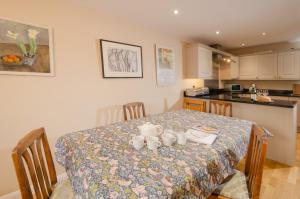 a kitchen with a table with a table cloth on it at Beck Steps, Elterwater in Chapel Stile