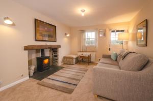 a living room with a couch and a fireplace at Beck Steps, Elterwater in Chapel Stile
