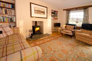 a living room with a couch and a fireplace at Beck Steps, Elterwater in Chapel Stile