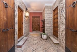 a hallway with wooden doors and a potted plant at Judería Suites in Córdoba