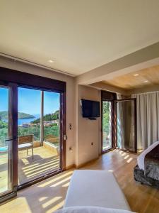 a bedroom with a bed and a balcony with a television at SAZ VILLAS in Syvota +40 photos