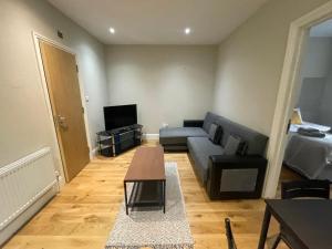 a living room with a couch and a table at Lovely 1 bedroom apartment with on street parking in London