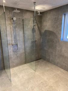 a shower with a glass door in a bathroom at Hytten in Lemvig