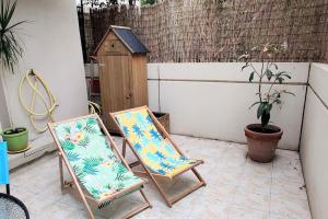 two chairs sitting on a patio with a bird house at Studio avec terrasse en bord de mer Marseille in Marseille