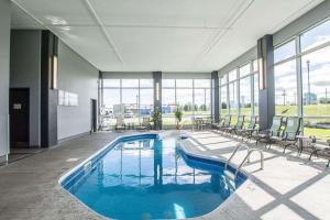 a large pool with chairs and a boat in a building at Quality Inn & Suites in Victoriaville