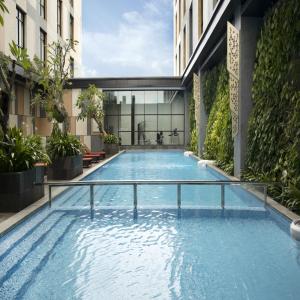 ein Schwimmbad in der Mitte eines Gebäudes in der Unterkunft Hotel Santika Premiere Padang in Padang
