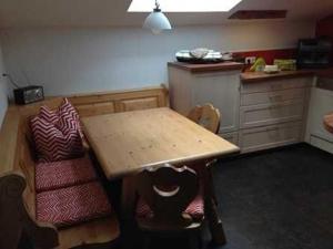 une cuisine avec une table en bois et deux chaises dans l'établissement Landhaus Rossberg, à Tannheim