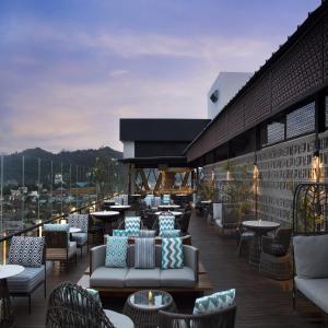Hotel Santika Premiere Padang في بادانج: فناء على أرائك وطاولات في مبنى