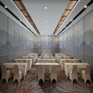 a large room with tables and chairs in it at Hotel Santika Premiere Padang in Padang