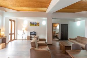 a living room with couches and a wooden ceiling at Pine Chalets by KA Group in Gudauri