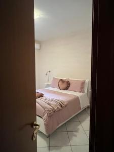una camera da letto con letto e lenzuola e cuscini rosa di Seaside apartment a Castellammare di Stabia