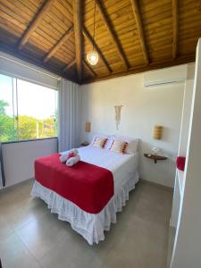 1 dormitorio con 1 cama grande con manta roja en Taipu de Fora - Villa Ohana Flats en Taipu