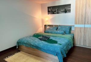 1 dormitorio con 1 cama con edredón verde en Lo-Fi Room on Ninman 12, en Chiang Mai