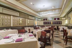 a dining room with white tables and chairs at Ambassador Hotel Milwaukee, Trademark Collection by Wyndham in Milwaukee