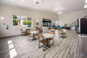 a restaurant with tables and chairs in a room at AmericInn by Wyndham Green Bay Near Stadium in Green Bay