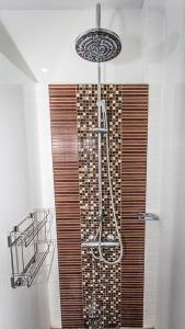 a shower in a bathroom with a wooden wall at Thararin Villa in Ban Doem Bang +102 photos