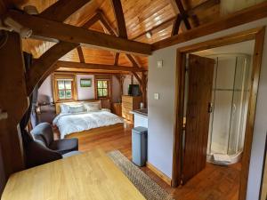 1 dormitorio con 1 cama en una habitación con techos de madera en Cabin in the Forest en Brockenhurst