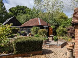 uma casa com um jardim com um quintal de tijolos em Cabin in the Forest em Brockenhurst