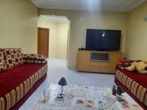 a living room with two couches and a flat screen tv at Casablanca in Aïn Harrouda