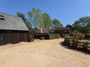 a barn with a fence and a dirt road at Cabin in the Forest in Brockenhurst