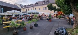 un grupo de personas sentadas en mesas con sombrillas en Landgasthof Reichsadler, en Höchstädt bei Thiersheim