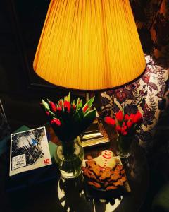 a table with two vases with flowers and a lamp at Phillipshaugen Lodge in Øksendalsøra