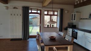 a kitchen with a wooden table with chairs and a window at FeWo Strohbrück in Quarnbek