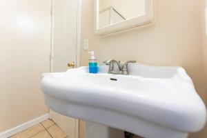a white sink in a bathroom with a mirror at A+ 2 BR Victorian Home away from Home in Sacramento +18 photos
